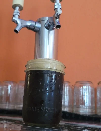 A beer sitting under the beer taps at the local brewery in bowling green