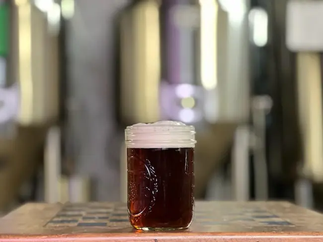 Pint of beer in front of the brew kettles at our brewery in bowling green 